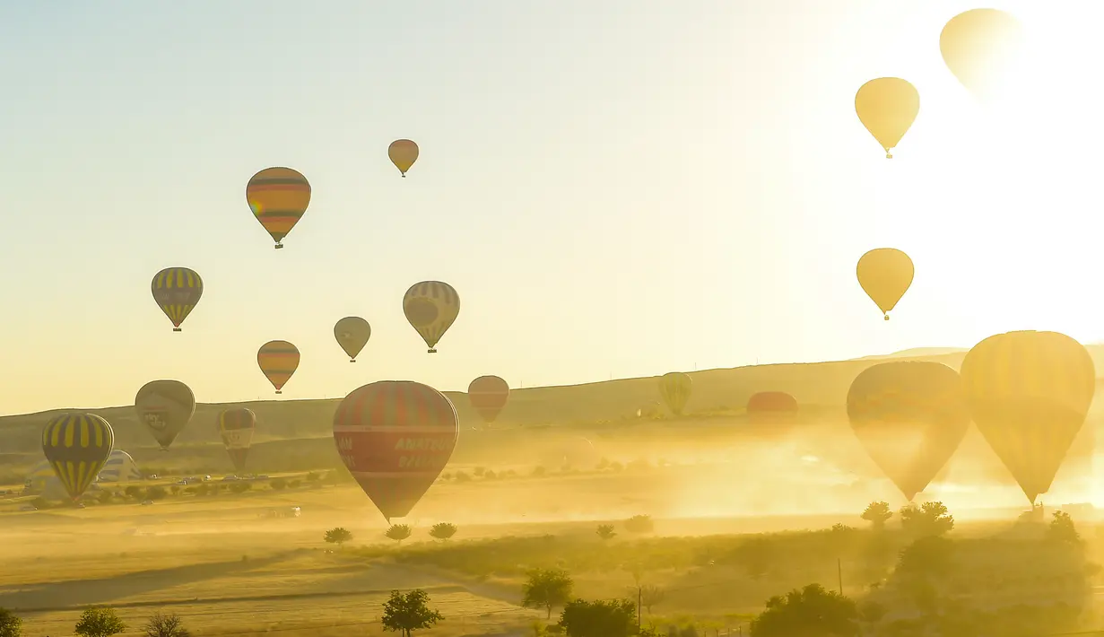 Balon udara panas lepas landas saat akan terbang di atas Nevsehir di wilayah Cappadocia, Turki (5/9). Cappadocia adalah tempat yang unik yang tujuan utama wisatawan yang datang ke Turki. (AFP Photo/Yasin Akgul)