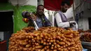 Para pedagang menata penganan manis untuk dijual saat bulan suci Ramadan di sebuah pasar di Sanaa, Yaman, Sabtu (25/4/2020). (Xinhua/Mohammed Mohammed)