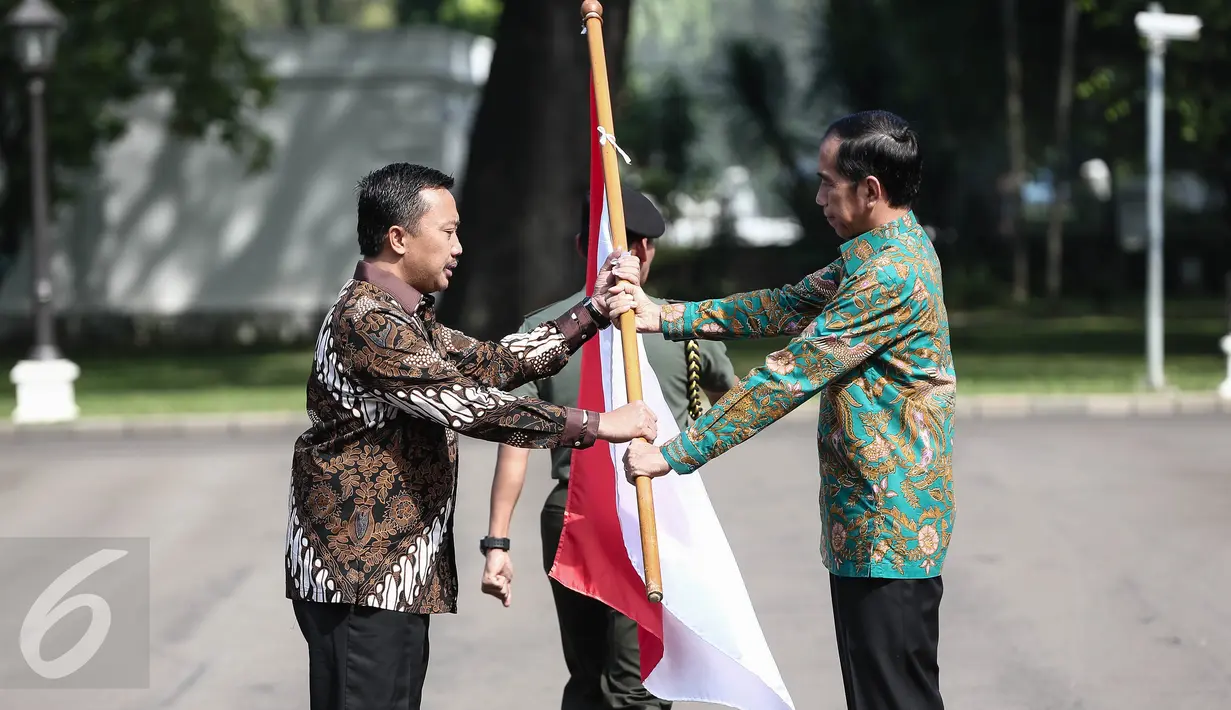 Presiden Jokowi menyerahkan bendera merah putih kepada Menpora Imam Nahrawi sebagai tanda pelepasan keberangkatan Tim Indonesia menuju Olimpiade 2016 di Brasil, di halaman Istana Merdeka, Jakarta, Rabu (22/6). (Liputan6.com/Faizal Fanani)