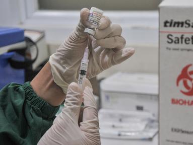 Petugas kesehatan mengambil serum saat vaksinasi dosis keempat atau Booster kedua di Puskesmas Kecamatan Pulogadung, Jakarta Timur, Selasa (24/1/2023). Dinas Kesehatan DKI mulai hari ini secara serentak menggelar vaksinasi dosis keempat atau Booster kedua bagi masyarakat umum berusia 18 tahun ke atas sebagai upaya meningkatkan kekebalan tubuh terhadap virus Covid-19. (merdeka.com/Iqbal S Nugroho)