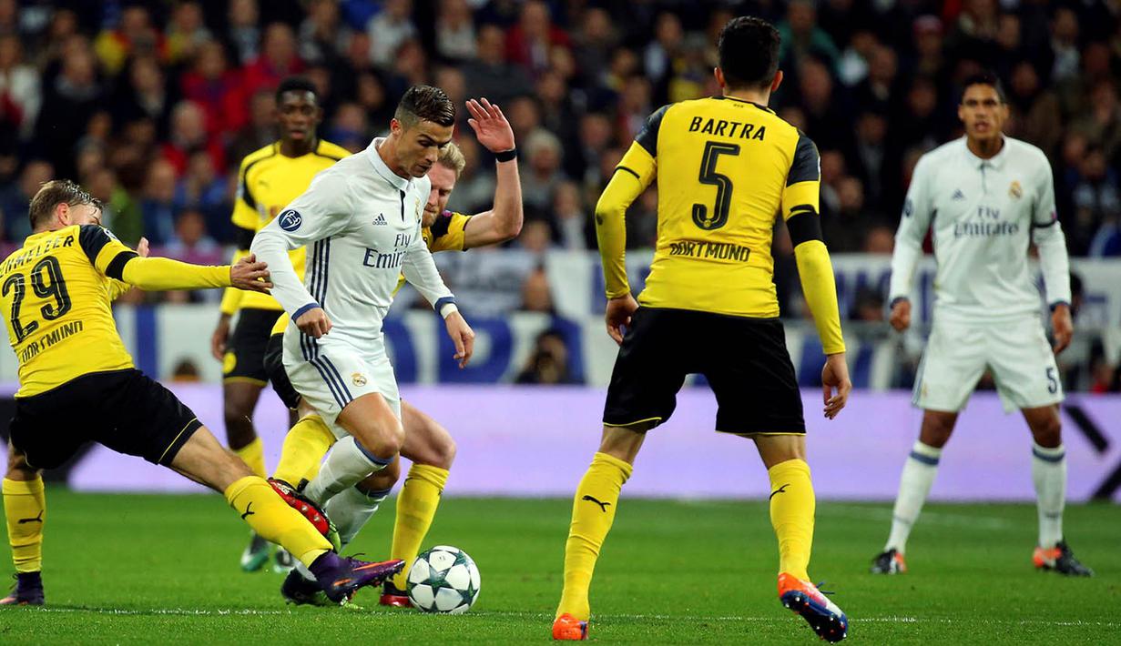 Bintang Real Madrid, Cristiano Ronaldo, berusaha lepas dari hadangan pemain Dortmund. Namun Dortmund akhirnya mampu menyamakan kedudukan menjadi 2-2 berkat gol Pierre-Emerick Aubameyang dan Marco Reus. (Reuters/Susana Vera)