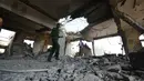 Petugas polisi memeriksa bangunan penjara al-Zaydiyah yang hancur terkena serangan jet tempur koalisi pimpinan Arab Saudi di kota Hodeidah, Yaman, Minggu (30/10). Serangan ini menewaskan sekitar 60 orang temasuk para tahanan. (REUTERS/Abduljabbar Zeyad)