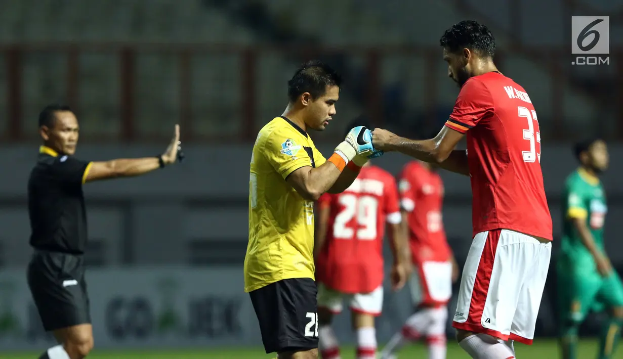 Kiper Persija, Andritany (tengah) keluar lapangan akibat cedera saat laga melawan Sriwijaya FC di lanjutan Liga 1 Indonesia di Stadion Wibawa Mukti, Cikarang Kab Bekasi, Jumat (16/6). Persija unggul 1-0. (Liputan6.com/Helmi Fithriansyah)