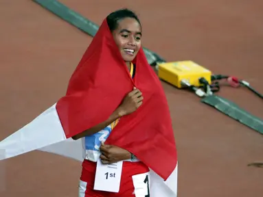 Atlet putri Indonesia, Triyaningsih saat melakukan perayaan kemenangannya di nomor 10.000 M di National Stadium Singapura, Kamis (11/6/2015). Triyaningsih mencatatkan waktu 33 menit 44,53 detik. (Liputan6.com/Helmi Fithriansyah)