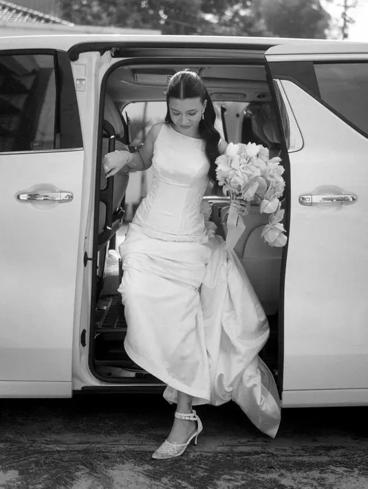 Cassandra Lee mengenakan gaun pengantin putih tulang lansiran @liv_atelier.id. Gaunnya hadir dalam siluet a-line sederhana dan sleeveless. [@liv_atelier.id].