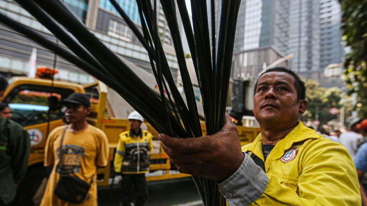 Petugas dari Dinas Bina Marga didampingi Jakarta Infrastruktur Propertindo (JIP) menarik kabel fiber optik yang semrawut saat melakukan penertiban di kawasan Jalan Senopati, Jakarta, Kamis (24/8/2023).