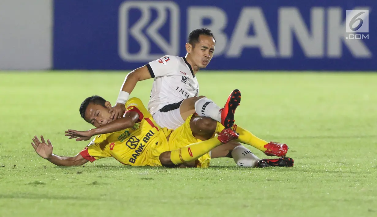 Pemain tengah Madura United, Slamet Nurcahyono (atas) berebut bola dengan penyerang Bhayangkara FC, Wahyu Subo Seto pada lanjutan Shopee Liga 1 Indonesia 2019 di Stadion Madya Gelora Bung Karno, Jakarta, Senin (5/8/2019). Laga kedua tim berakhir imbang 1-1. (Liputan6.com/Helmi Fithriansyah)