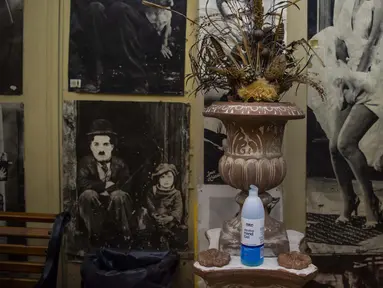 Gel hidroalkohol dipajang dekat poster masa lalu Marilyn Monroe dan Charlie Chaplin di lobi bioskop terbuka Oasis, Athena, Yunani, 1 Agustus 2020. Pandemi COVID-19 memaksa bioskop terbuka dipersingkat sehingga menyebabkan penurunan jumlah penonton. (ANGELOS TZORTZINIS/AFP)