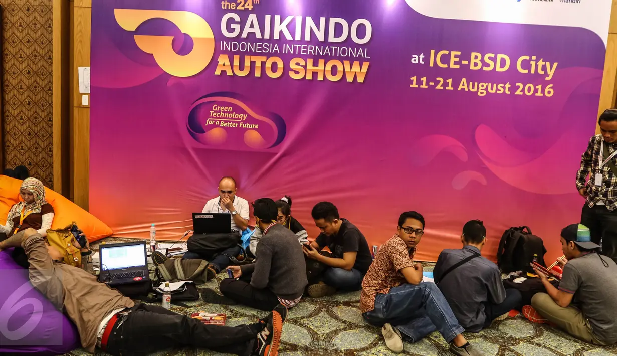 Sejumlah jurnalis sedang mengetik berita sambil duduk lesehan saat Gaikindo Indonesia International Auto Show (GIIAS) di pressroom ICE BSD, Tangerang Selatan (11/08). (Liputan6.com/Fery Pradolo)