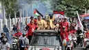 <p>Sejumlah pemain Malut United menaiki mobil bak terbuka saat mengikuti konvoi di Kota Ternate, Maluku Utara pada Kamis (14/03/2024). (Bola.com/Hery Kurniawan)</p>