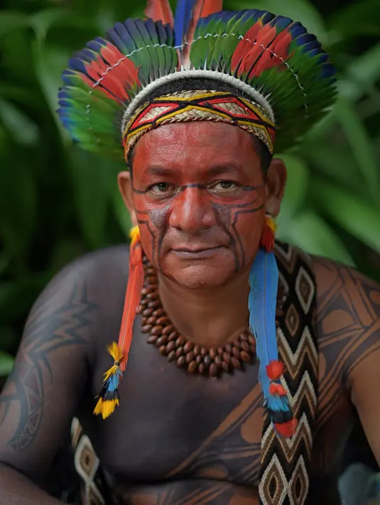 Seorang pria bernama Garapira dari suku Pataxo berpose untuk difoto di Rio de Janeiro, Brasil (14/4). Brasil merayakan Indian Day yang digelar setiap tanggal 19 April untuk menghormati masyarakat adat dan budaya setempat. (AFP/Carl De Souza)