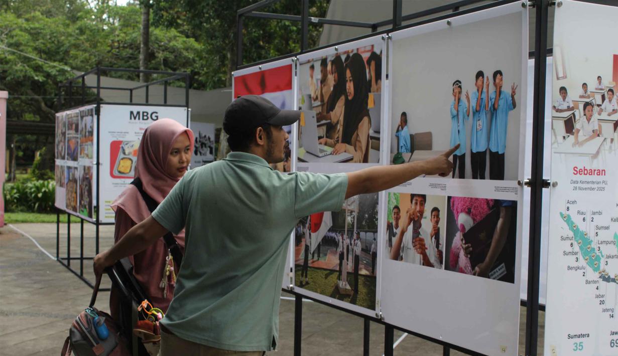 Seluruh karya tersebut mengangkat capaian dan pelaksanaan program-program prioritas pemerintahan Presiden Prabowo Subianto dan Wakil Presiden Gibran Rakabuming Raka. Tampak dalam foto, pengunjung menyaksikan karya foto jurnalistik dalam pameran Haluan Merah Putih Roadshow yang digelar di Selasar Kantin Taman Margasatwa Ragunan, Jakarta Selatan, Rabu (24/12/2025). (merdeka.com/magang/Rendi Saputra)