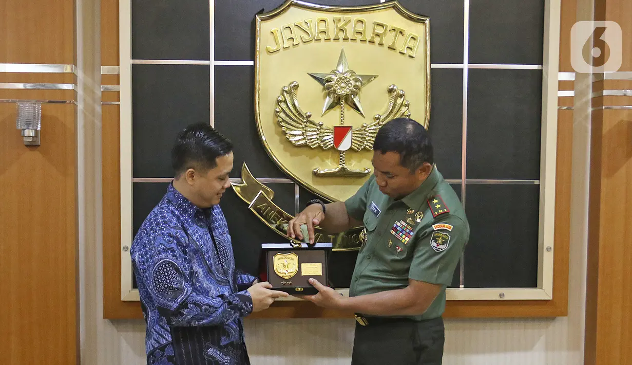 Pangdam Jaya Mayjen TNI Eko Margiyono memberikan plakat ke Director Programming SCTV, David Suwarto  seusai kunjungan di Makodam Jaya, Jakarta, Selasa (10/12/2019). Kunjungan ini untuk menjalin hubungan kedua pihak. (Liputan6.com/Herman Zakharia)