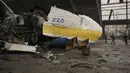 Prajurit Ukraina melewati pesawat Antonov An-225 Mriya yang hancur di bandara Antonov, Hostomel, 2 April 2022. Di pintu masuk Bandara Antonov, pasukan menjaga posisinya, tanda mereka memegang kendali penuh atas landasan pacu yang coba diserbu Rusia di hari-hari pertama perang (AP Photo/Vadim Ghirda)
