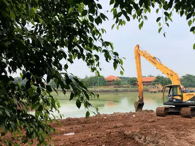 Petugas menggunakan alat berat untuk mengeruk lumpur di kawasan Setu Babakan, Jakarta, Rabu (21/10/2020). Gubernur DKI Jakarta Anies Baswedan mengatakan, program pengerukan lumpur kali, sungai, atau waduk di Jakarta akan dilakukan hingga akhir tahun 2020. (Liputan6.com/Immanuel Antonius)