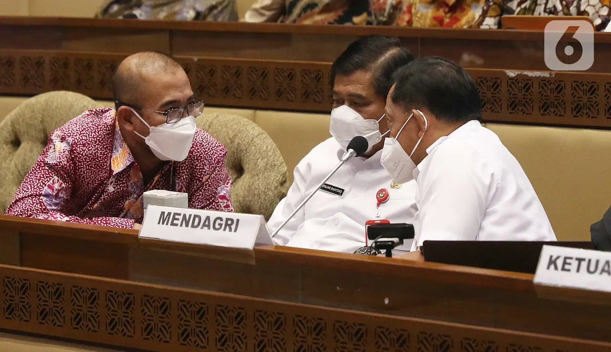 Menteri Dalam Negeri Tito Karnavian (kiri) berbincang dengan Ketua KPU Hasyim Asyari saat rapat kerja bersama Komisi II DPR RI di Kompleks Parlemen, Jakarta, Rabu (13/4/2022). Raker tersebut membahas persiapan pemilu serentak pada 2024. (Liputan6.com/Angga Yuniar)