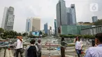 Sejumlah warga berswafoto di tengah polusi di anjungan Halte Transjakarta, kawasan Bundaran Hotel Indonesia (HI), Jakarta, Sabtu (23/9/2023). (Liputan6.com/Faizal Fanani)