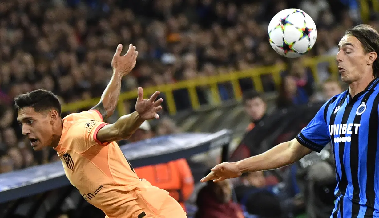 Bek Atletico Madrid Nahuel Molina berebut bola dengan gelandang Club Brugge  Casper Nielsen pada matchday ketiga Grup B Liga Champions 2022/23 di Jan Breydel Stadium, Rabu (5/10/2022) dinihari WIB. Duel Club Brugge vs Atletico Madrid berkesudahan dengan skor 2-0 kemenangan tuan rumah. (AP Photo/Geert Vanden Wijngaert)