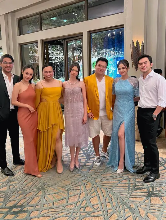 Gaun bridesmaid dalam warna mustard dipakai fashion stylist Wanda Haraa. Bersama jas senada yang dikenakan MUA Ryan Ogilvy. [@wanda_haraa]