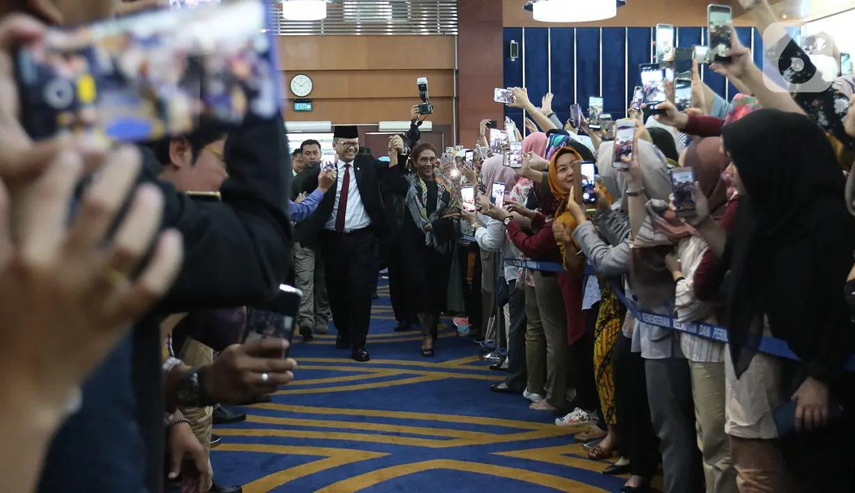 Edhy Prabowo (kiri) bersama Susi Pudjiastuti menyapa para karyawan jelang acara serah terima jabatan (Sertijab) Menteri Kelautan dan Perikanan di Kantor KKP, Jakarta, Rabu (23/10/2019). Edhy menggantikan Susi Pudjiastuti pada Kabinet Indonesia Maju periode 2019-2024. (Liputan6.com/Herman Zakharia)