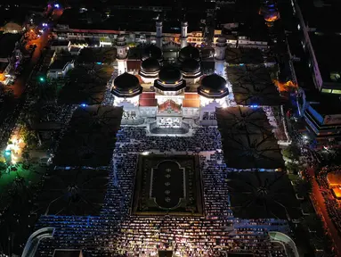 Foto dari udara memperlihatkan umat muslim sedang melaksanakan sholat tarawih pertama sekaligus menandai dimulainya bulan suci Ramadhan di Masjid Raya Baiturrahman, Banda Aceh, Rabu (22/3/2023). (CHAIDEER MAHYUDDIN/AFP)