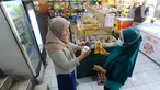Pedagang melakukan scan KTP pembeli minyak goreng curah di Toko Tjandra, Cinere, depok, Jumat (03/06/2022). Paska dicabutnya kebijakan subsidi minyak goreng curah, pembeli minyak goreng curah di pasaran diwajibkan menyertakan kartu tanda penduduk (KTP) dengan maksimal 1 ktp untuk 2 liter minyak goreng curah seharga Rp 14.000/liter. (merdeka.com/Arie Basuki)
