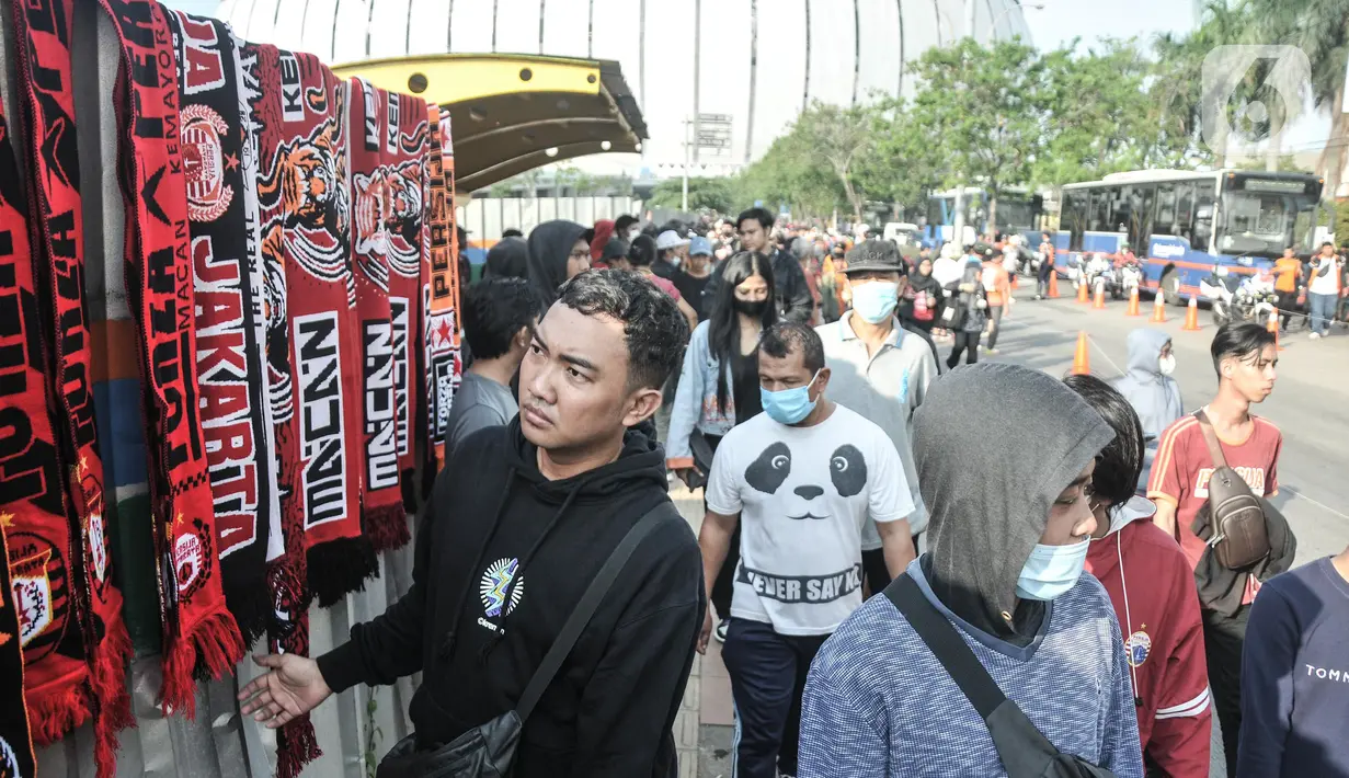 Suporter Persija Jakarta atau The Jakmania membeli atribut yang dijual di sekitar pintu masuk Jakarta International Stadium (JIS), Papanggo, Jakarta Utara, Minggu (24/7/2022). (merdeka.com/Iqbal S. Nugroho)