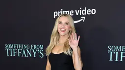 Reese Witherspoon menyapa melambaikan tangan saat menghadiri pemutaran perdana film "Something From Tiffany's" di Los Angeles di AMC Century City 15 di Century City, California pada 29 November 2022. Wanita 46 tahun itu mengenakan gaun hitam kecil yang berakhir di lututnya. (Amy Sussman/Getty Images/AFP)