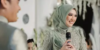 Saat lamaran, Happy pun tampil serba hijau mengenakan kerudung yang dipadukan dress berpayet. Ia pun tampil serasi dengan Gilda yang kini sudah menjadi suaminya. [@ulfamerdekapartyplanner]