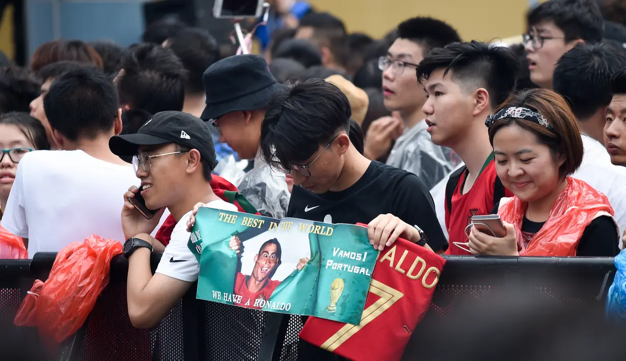 Para penggemar menunggu kedatangan pemain timnas Portugal, Cristiano Ronaldo menemui para penggemarnya dalam rangkaian “CR7 Tour” di Beijing, China, Kamis (19/7). Ronaldo mendapatkan sambutan meriah dari pendukunganya yang ada di sana. (WANG ZHAO/AFP)