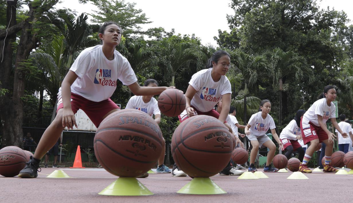 Sejumlah siswa mengikuti pelatihan oleh Legenda NBA, Jason Richardson, di SMA 82 Jakarta, Kamis (28/3). Kunjungan peraih dua gelar juara kontes slamdunk NBA tersebut merupakan bagian dari rangkaian program Jr NBA. (Bola.com/M Iqbal Ichsan)