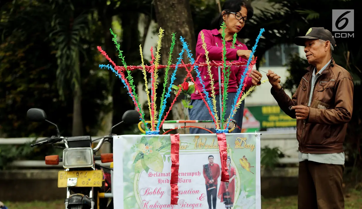 Warga sedang menghias Betor (becak motor) di depan kantor Dinas Perhubungan, Medan, Sumatera Utara, Sabtu (25/11). Puluhan betor akan ramaikan kirab budaya ngunduh mantu Kahiyang-Bobby. (Liputan6.com/Endang Mulyana)