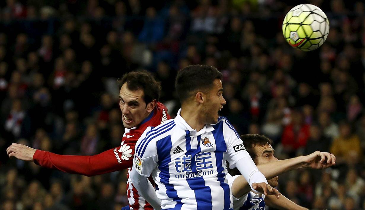 Pemain Atletico Madrid, Diego Godin (kiri) berebut bola dengan pemain Real Sociedad, Diego Reyes pada lanjutan La Liga di Vicente Calderon, Madrid, Rabu (2/3/2016) dini hari WIB. (REUTERS/Juan Medina)