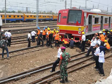 Sejumlah Petugas saat mengevakuasi gerbong kereta yang anjlok di jalur kereta api manggarai, Jakarta, Selasa (27/10/2015). Para Penumpang berhamburan turun  menyelamatkan diri. (Liputan6.com/Gempur M Surya)