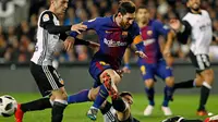 Striker Barcelona Lionel Messi dihadang dua pemain Valencia saat pertandingan Copa del Rey di stadion Mestalla di Valencia (8/2). Dengan hasil kemenangannya, Barcelona sukses memastikan tiket ke final Copa del Rey. (AP Photo/Alberto Saiz)