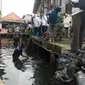 Para petinggi BUMN dan warga Kelurahan 1 Ilir gotong royong membersihkan Sungai Tali Gawe Palembang yang banyak sampah, berbau menyengat dan berwarna hitam pekat (Liputan6.com / Nefri Inge)