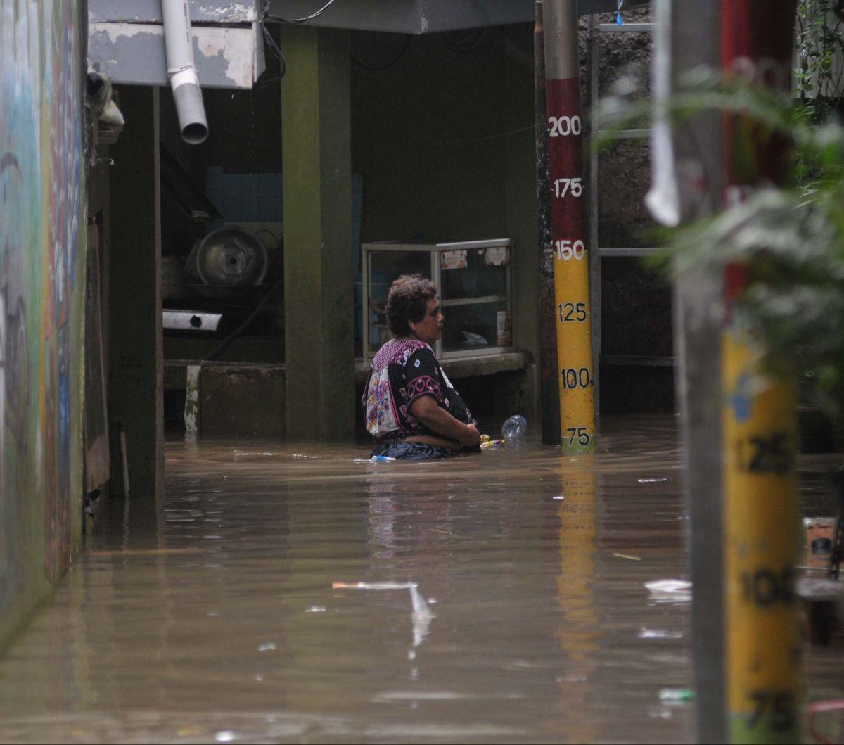 Seorang warga berjalan melewati banjir merendam permukiman di Kebon Pala, Jatinegara, Jakarta, Selasa (2/7/2024).&nbsp;Banjir ini terjadi akibat luapan Kali Ciliwung seiring tingginya intensitas hujan di wilayah Depok dan Bogor, Jawa Barat.&nbsp;Merdeka.c