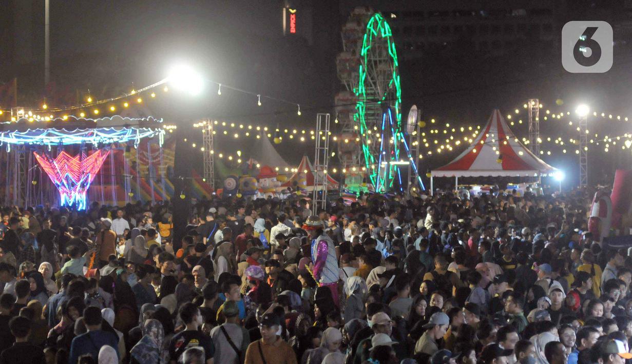 Warga antre naik wahana permainan komidi putar pada malam Jaya Raya Jakarnaval, atau Jakarta Night Carnaval Jakarta di kawasan Monumen Nasional, Sabtu (22/6/2024). (merdeka.com/Imam Buhori)