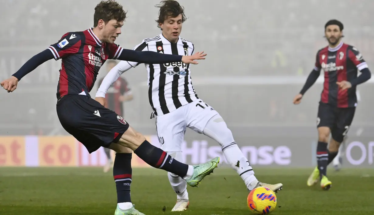 Bek Juventus Luca Pellegrini berebut bola dengan penyerang Bologna Andreas Skov Olsen pada laga pekan ke-18 Liga Italia di Stadio Renato Dall'Ara, Minggu (19/12/2021) dini hari WIB. Bertamu ke markas Bologna, Juventus sukses mengalahkan tuan rumah dengan skor 2-0. (Massimo Paolone/LaPresse via AP)