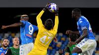 Penjaga gawang Sassuolo, Andrea Consigli, menangkap bola diantara dua pemain Napoli, Victor Osimhen (kiri) dan Kalidou Koulibaly dalam lanjutan Liga Italia Serie A di Stadion San Paolo, Napoli, Minggu (1/11/2020). Napoli takluk 0-2 dari Sassuolo. (AFP/Tiziana Fabi)