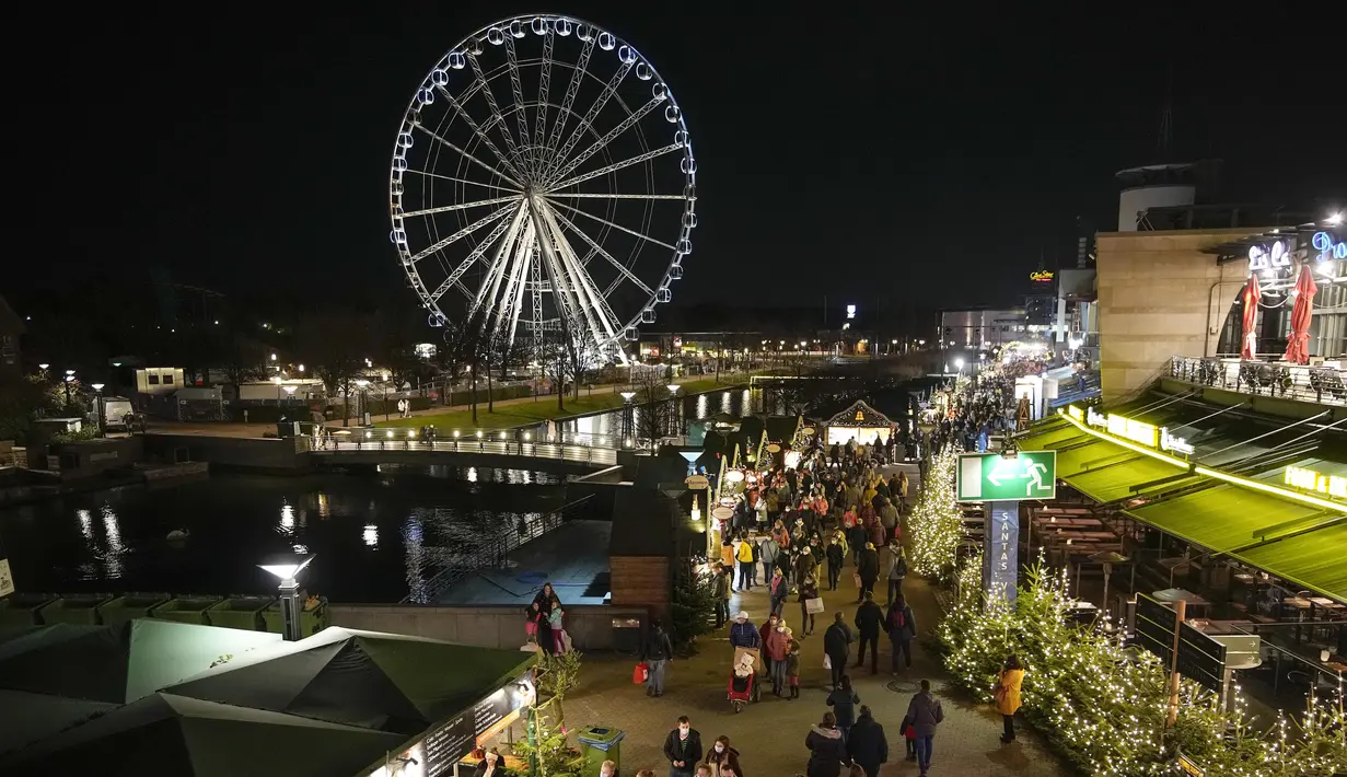 Orang-orang mengunjungi pembukaan pasar Natal besar di pusat perbelanjaan Westfield Centro di Oberhausen, Jerman, Jumat (12/11/2021).  Pasar di Oberhausen juga mewajibkan pengunjung untuk tetap memakai masker. (AP Photo/Martin Meissner)