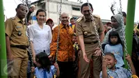 Gubernur DKI Jakarta Basuki T Purnama didampingi istri, Veronica Tan (kedua kiri) meninjau anak-anak yang tengah bermain ayunan usai meresmikan Ruang Publik Terpadu Ramah Anak (RPTRA) Karet Tengsin, Jakarta, Rabu (30/12). (Liputan6.com/Yoppy Renato)