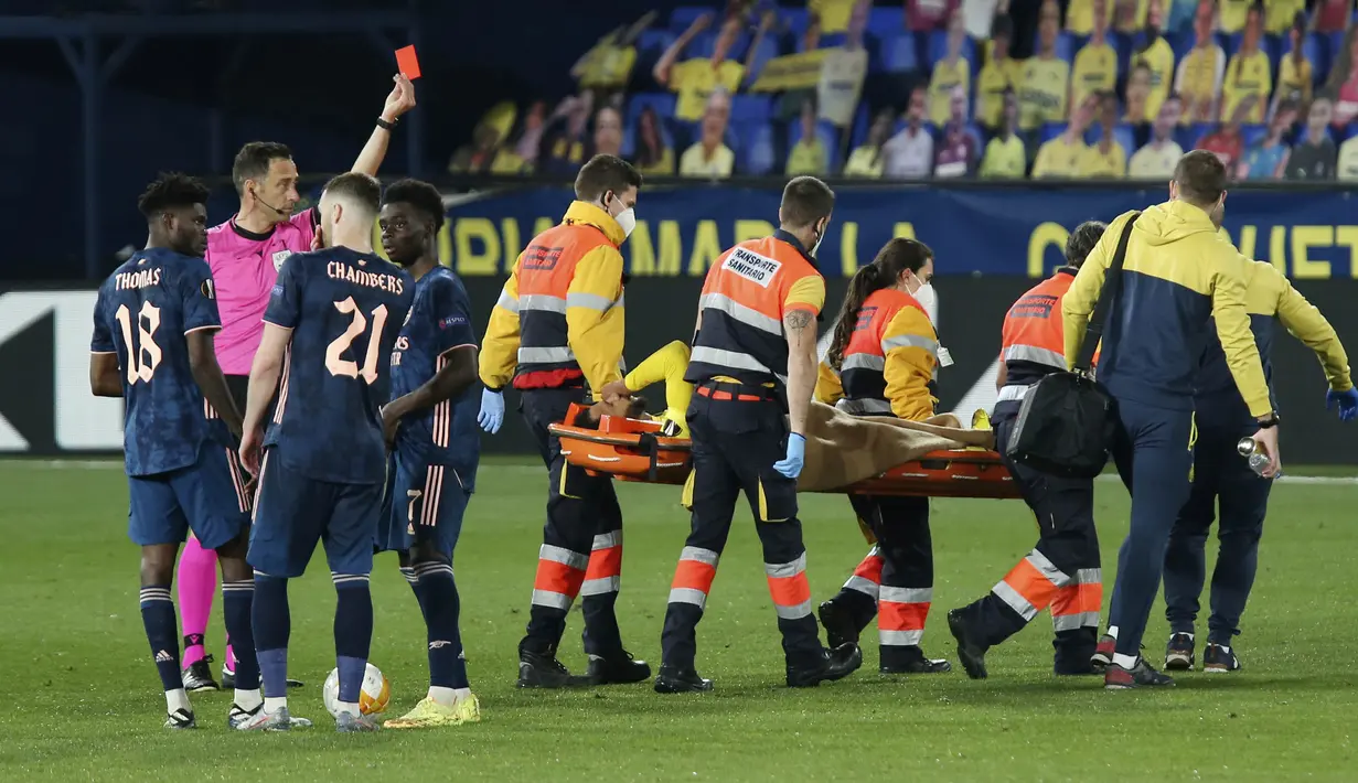 Pemain Villareal, Etienne Capoue, mendapata kartu merah dari wasit saat melawan Arsenal, Rob Holding, pada laga Liga Europa di Stadion Ceramica, Jumat (30/4/2021). Villareal menang dengan skor 2-1. (AP/Alberto Saiz)