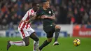 Aksi pemain Stoke City, Kurt Zouma (kiri) menahan laju pemain Manchester City, Gabriel Jesus pada lanjutan Premier League di Bet 365 Stadium, Stoke, (13/3/2018). Manchester City menang 2-0. (AFP/Paul Ellis)