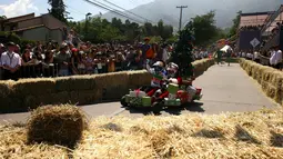 Salah satu peserta mengendarai kendaraannya dalam ajang balap mobil 'Kotak sabun' Red Bull Soapbox di Santiago, Chili, Minggu (27/11). Para pengemudi mengandalkan gaya gravitasi bumi karena kendaraan mereka tidak memiliki mesin. (REUTERS/Jonathan Faus)