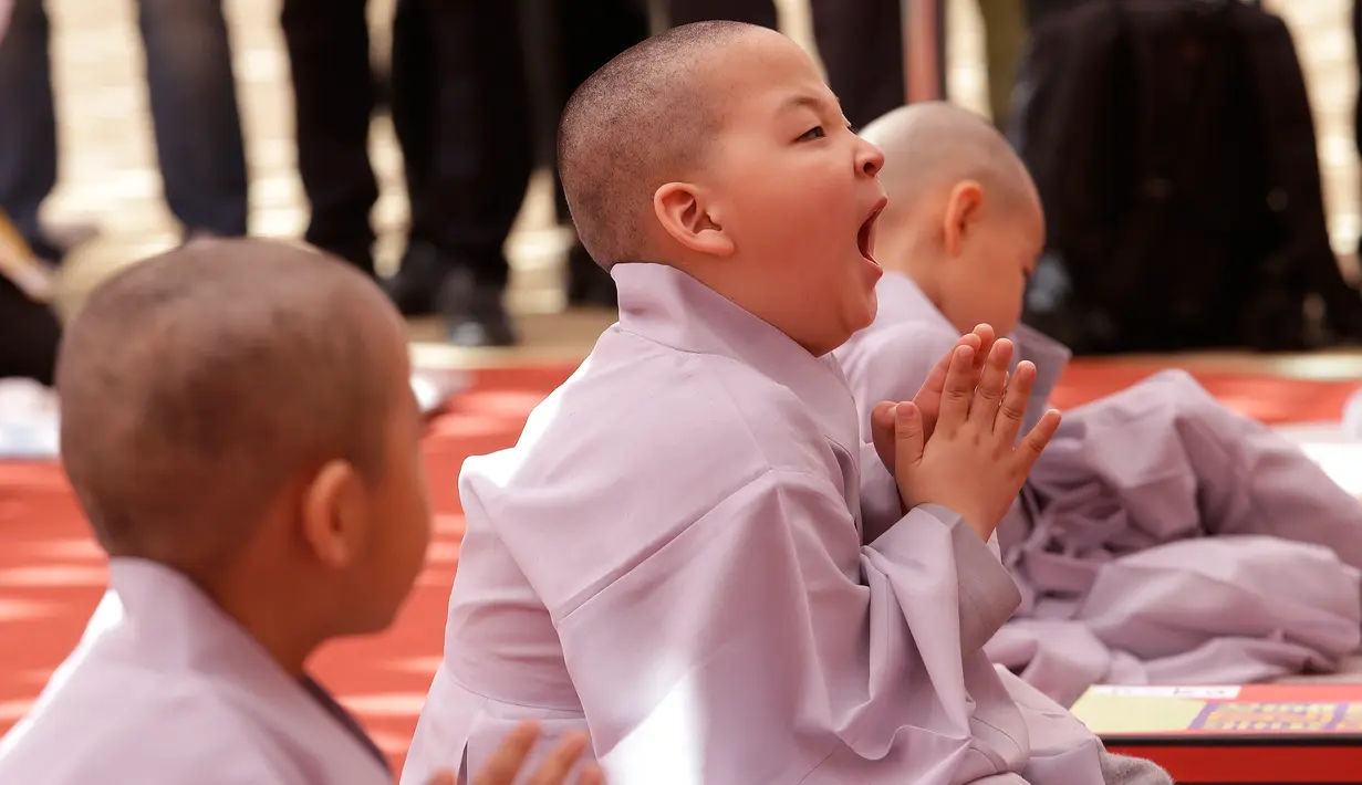 Seorang anak lelaki bernama Budha Bon Young menguap setelah kepalanya dicukur saat kebaktian merayakan ulang tahun ke-2.563 Buddha di Kuil Jogye di Seoul, Korea Selatan, Senin (22/4). Perayaan ulang tahun Buddha akan jatuh pada 12 Mei mendatang. (AP Photo/Ahn Young-joon)