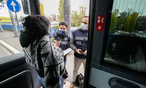 Polisi Carabinieri memeriksa kartu kesehatan Covid-19 penumpang bus pada hari pertama pemberlakuan ‘Super Green Pass’ di Roma, Senin (6/12/2021). Polisi Italia dapat memeriksa apakah pengunjung memiliki Green Pass yang menunjukkan bukti vaksinasi atau kesembuhan dari virus. (AP/Andrew Medichini)
