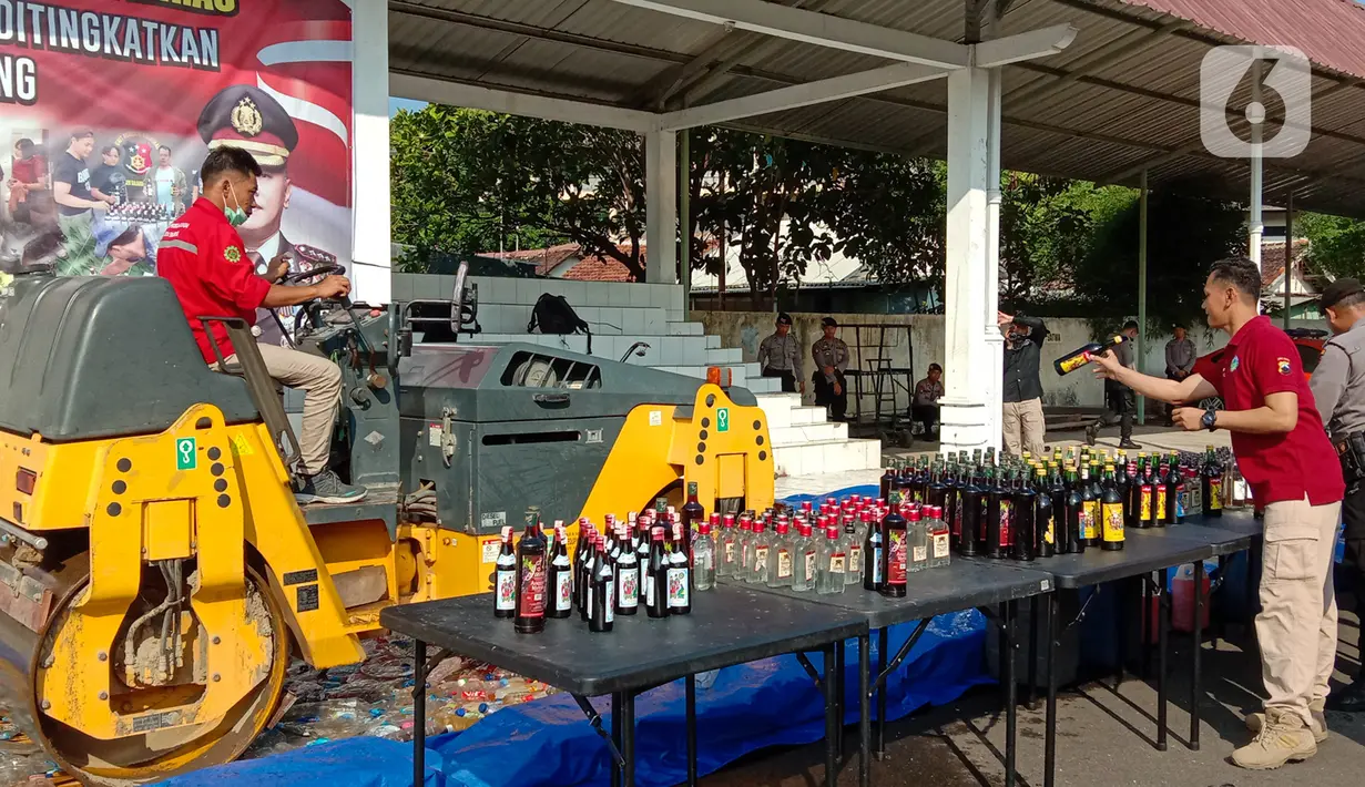 Petugas dengan alat berat menghancurkan botol minuman keras (miras) saat pemusnahan Miras dan barang bukti narkotika di Mapolrestabes Semarang, Jumat (20/12/2019). Pemusnahan barang bukti Narkotika khususnya Sabu dan Minuman Keras hasil penindakan selama setahun terakhir. (Liputan6.com/Gholib)
