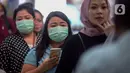 Calon penumpang kereta api mengenakan masker saat berada di Stasiun Gambir, Jakarta Pusat, Jumat (31/01). Dalam rangka pencegahan Virus Corona, PT Kereta Api Indonesia (persero) melakukan sosialisasi kepada penumpang dengan membagi-bagikan masker di stasiun Gambir. (merdeka.com/Imam Buhori)