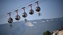 Sejumlah pembalap sepeda tergantung di bawah kereta gantung Grenoble Bastille pada ajang Tour de France di Grenoble, Rabu (16/9/2020). (AFP/Anne-Christine Poujoulat)
